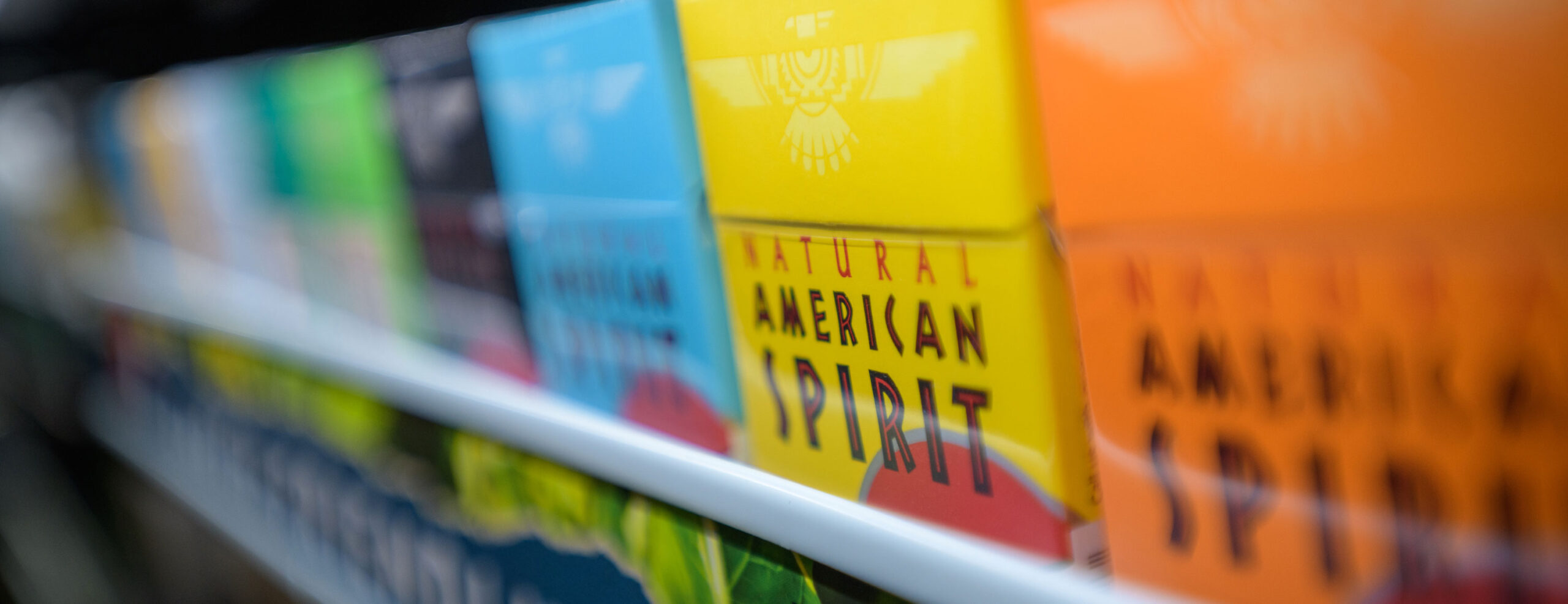 Close-up of boxes of Reynolds' cigarette brands on a store shelf.