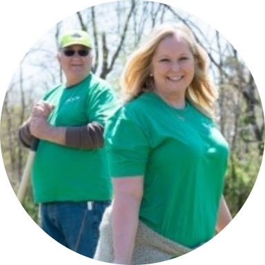 Two Reynolds American employee volunteers in green shirts standing outside.