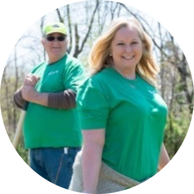 circle_image_column_1 Two Reynolds American employee volunteers in green shirts standing outside.