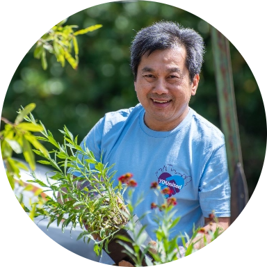 Reynolds American employee holding a green plant while volunteering in the community.