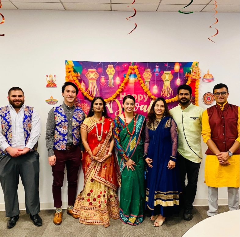 Reynolds American employees dressed in traditional Indian outfits, standing in front of a banner that says, "Happy Diwali."