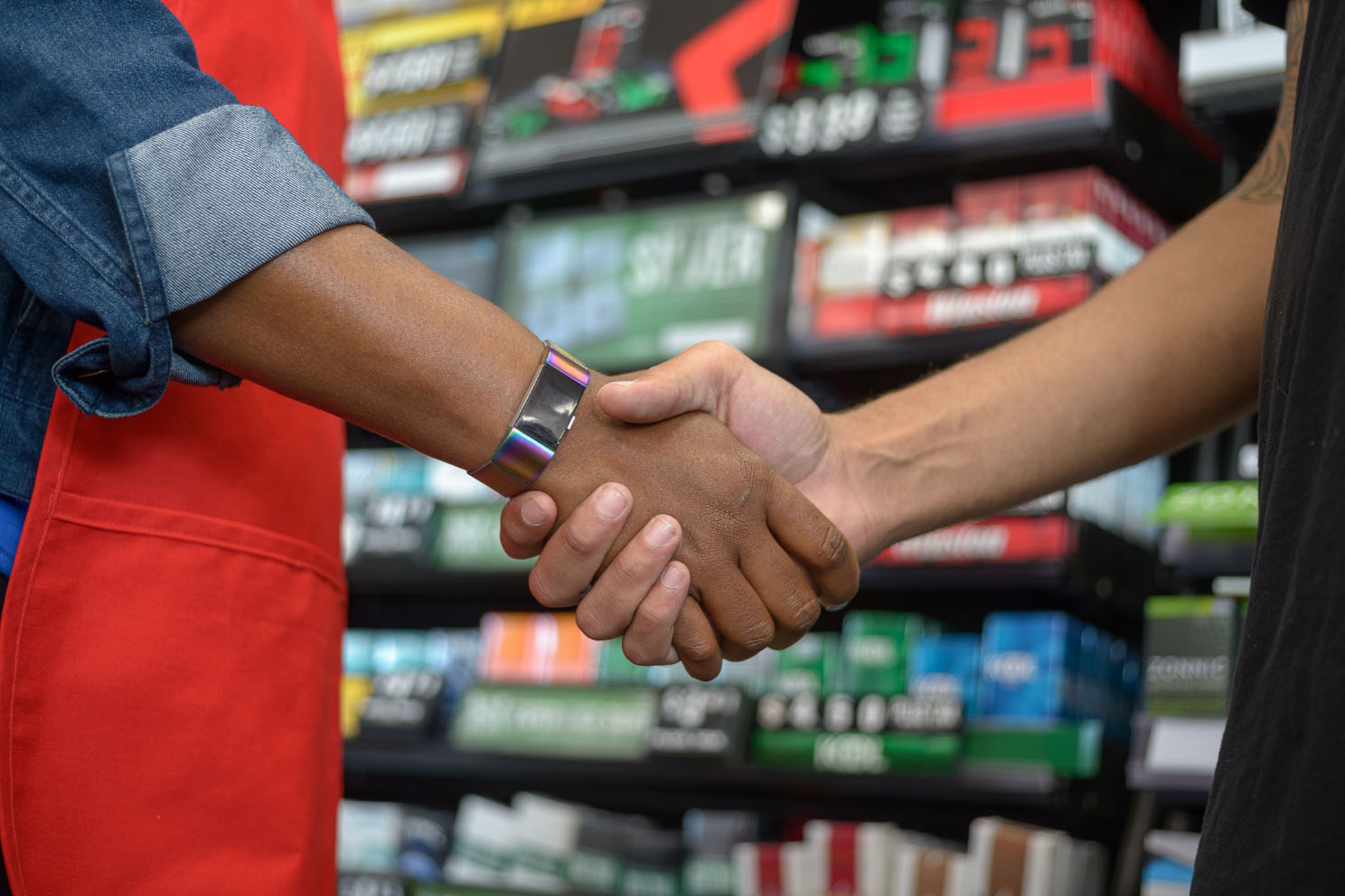 Close-up of store employee in checking IDs prior to sale, representing stores selling tobacco committed to youth access prevention.